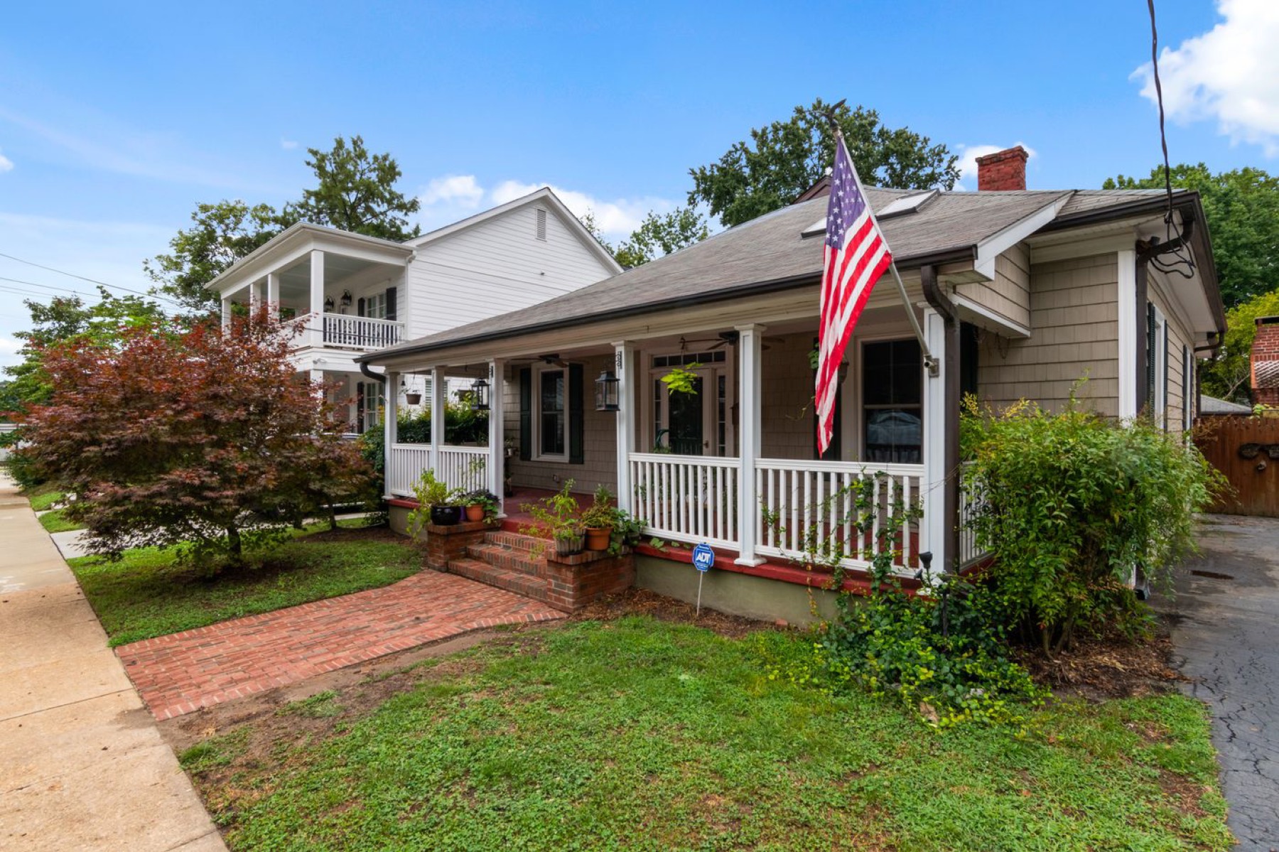 A single-family home with a covered front porch and brick path.